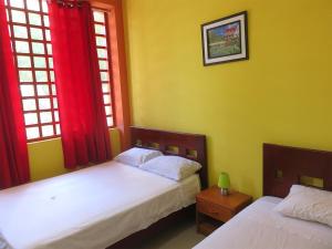 dwa łóżka w pokoju z dwoma oknami w obiekcie Hospedaje Purma Wasi w mieście Tarapoto