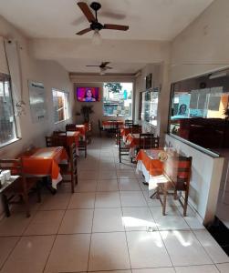 a restaurant with tables and chairs and a ceiling fan at Shalon Hotel in Uberaba