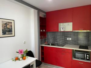 a kitchen with red cabinets and a white table at Villa Perivoli in Parga +65 photos