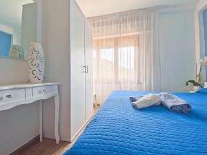 una camera con un letto blu con due cuscini sopra di Apartment Dissoro a Santa Maria Navarrese