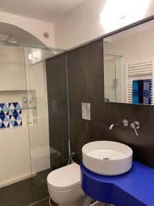 een badkamer met een toilet, een wastafel en een spiegel bij La casetta in Napels