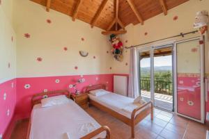 a bedroom with two beds and a balcony at Donatos (Δονάτος) in Finikounta