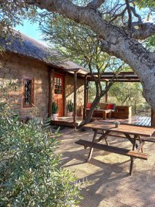 a picnic table in front of a stone house at Five Pebbles on Piece of Africa in Cullinan