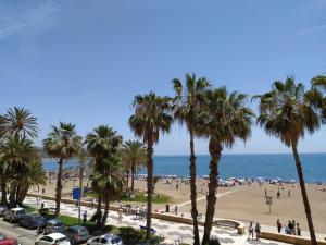 a view of a beach with palm trees and the ocean at Sunbeach Malagueta in Málaga +19 photos