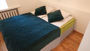 uma cama com duas almofadas verdes em cima em City Centre Kreutzwaldi apartment em Talin