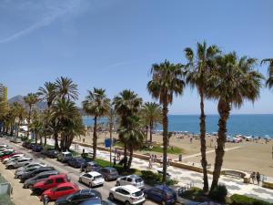 a parking lot with palm trees and the beach at Sunbeach Malagueta in Málaga