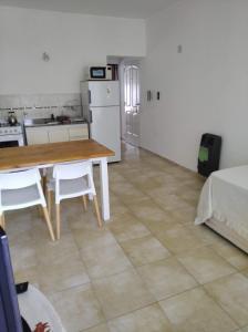 eine Küche und ein Esszimmer mit einem Tisch und einem Kühlschrank in der Unterkunft Departamentos Defensa Sur in Concepción del Uruguay