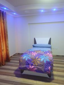 a bedroom with a bed with a colorful blanket at سكن للذكور فقط - Sakan Male Only in 6th Of October