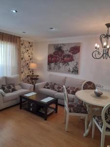 - un salon avec un canapé et une table dans l'établissement Apartamento ALBAMAR SANXENXO, à Sanxenxo