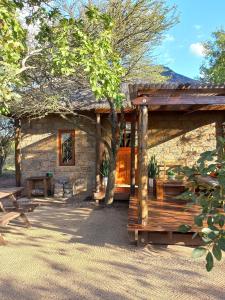 a log cabin with a bench and a table at Five Pebbles on Piece of Africa in Cullinan