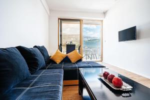 布德瓦的住宿－Victoria Top View，客厅配有蓝色的沙发和玻璃桌