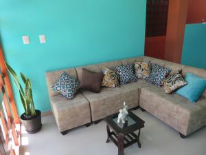 sala de estar con sofá y almohadas en Hospedaje Purma Wasi, en Tarapoto