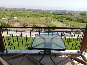 een glazen tafel op een balkon met uitzicht bij ΕΞΟΧΙΚΟ ΣΤΟΥΣ ΠΡΟΠΟΔΕΣ ΤΟΥ ΟΛΥΜΠΟΥ in Leptokarya