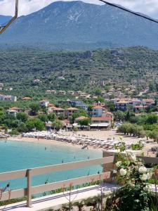 a beach with umbrellas and people in the water at Lighthouse Apartments in Stoupa