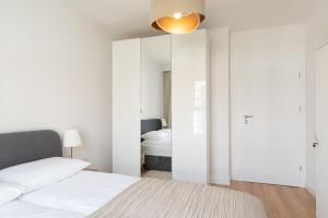 una camera bianca con letto e specchio di Rakowska Home a Varsavia