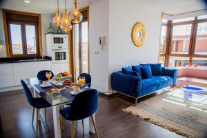 een woonkamer met een blauwe bank en een tafel en stoelen bij Mirador Islas de Arosa in Ribeira
