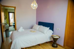 a bedroom with a white bed with a blue headboard at Mirador Islas de Arousa in Ribeira