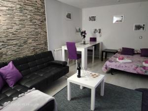- un salon avec un canapé, des tables et des oreillers violets dans l'établissement El Rincón de La Maña, à Logroño