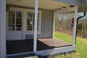 een afgeschermde veranda met een witte deur en ramen bij Lake and Forest Hideaway in Årjäng