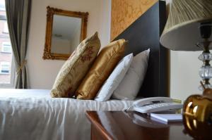 a bed with a white comforter and pillows on it at Dublin Citi Hotel of Temple Bar in Dublin