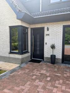 een voordeur van een huis met een potplant bij Bed&Bubbels 256 in De Koog