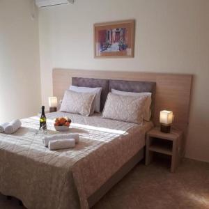 a bedroom with a bed with a bowl of fruit on it at Lovely Anna's Apartments in Sarandë