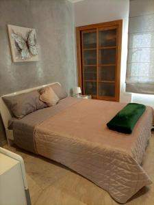 a bedroom with a large bed with a green pillow on it at Cozy & Luxurious apartment with seaview in Bouznika