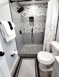 a white bathroom with a shower and a toilet at STUDIO 4A in Lakeland +9 photos