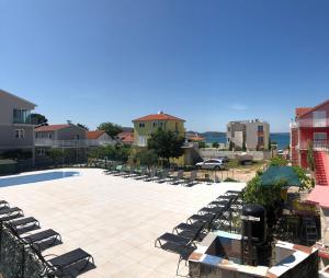 a patio with lounge chairs and a swimming pool at Lipovac resort Ficus in Bilice