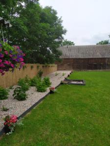 d'un jardin fleuri, d'une clôture et d'une cour. dans l'établissement Dom w malowniczej wsi z imprezową stodołą Hot Tub jacuzzi, à Zakrzewo Zalesie