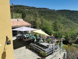 un patio con mesas y sombrillas frente a una casa en Chambre d'hôtes casa di l'apa, en Venaco