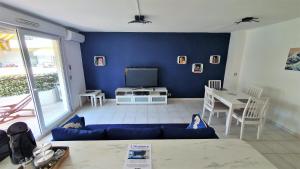 ein Wohnzimmer mit einem Sofa und einem TV in der Unterkunft L'Atalante, 2 pièces 47m2 rénové résidence piscine in Villeneuve-Loubet
