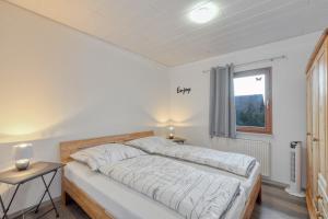 ein Schlafzimmer mit einem Bett mit weißen Laken und einem Fenster in der Unterkunft Ferienhaus bei Zoe mit Sauna in Kirchheim