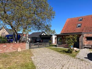 une maison en briques avec une clôture et un arbre dans l'établissement Zierow Ostsee, à Zierow