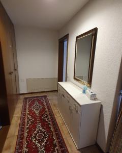 a bathroom with a sink and a mirror and a rug at Abschalten vom Alltag in Brissago in Brissago