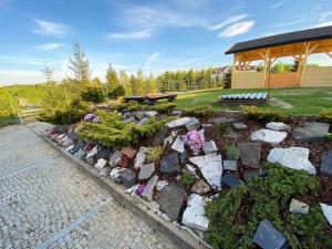a garden with a bench and flowers in front of a pavilion at Willa Różana in Wola Kalinowska