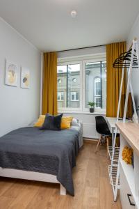 Schlafzimmer mit einem Bett, einem Schreibtisch und einem Fenster in der Unterkunft Cosy Pepleri place in Tartu