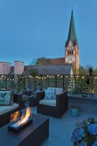 un patio avec des canapés et un foyer extérieur sur le toit dans l'établissement Apartamenty Strażacka - Loft Brooklyn, à Szczecinek