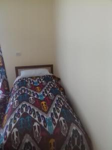 a bed with a colorful comforter in a bedroom at Ancient Khiva in Khiva