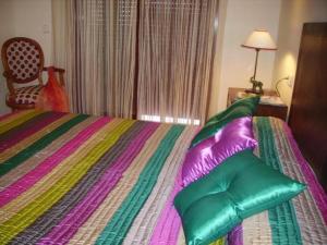 sypialnia z łóżkiem z kolorową pościelą i poduszkami w obiekcie Málaga, Mijas, La Cala, apartamento vacaciones de ensueño w mieście La Cala de Mijas +28 zdjęć