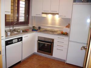 a kitchen with white cabinets and a sink and a dishwasher at Málaga, Mijas, La Cala, apartamento vacaciones de ensueño in La Cala de Mijas
