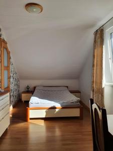 a bedroom with a bed in a attic at Sunset Holidays - Dom nad Jeziorem in Żarnowska