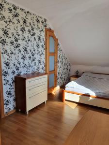 a bedroom with a bed and a dresser at Sunset Holidays - Dom nad Jeziorem in Żarnowska +27 photos
