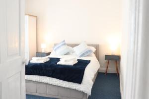 a bedroom with a bed with blue and white pillows at Spacious & Comfortable 3 Bedroom House - FREE WiFi & FREE Parking in Killingbeck