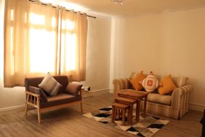 uma sala de estar com duas cadeiras e um sofá em Spacious & Comfortable 3 Bedroom House - FREE WiFi & FREE Parking em Killingbeck