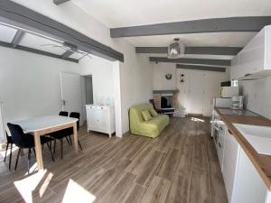 a kitchen and living room with a table and a dining room at Maison bord de lac de charmes in Bannes +21 photos