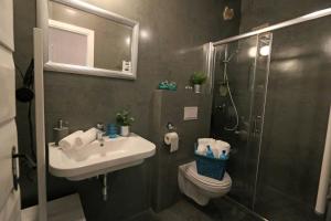La salle de bains est pourvue d'une douche, d'un lavabo et de toilettes. dans l'établissement Val & Mar Studio Apartment, à Zadar