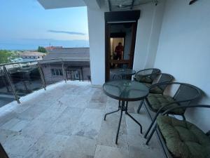 a patio with a table and chairs on a balcony at Vila Adelis in Vama Veche +16 photos