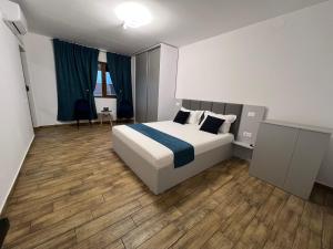 a bedroom with a bed with a blue and white blanket at Vila Adelis in Vama Veche