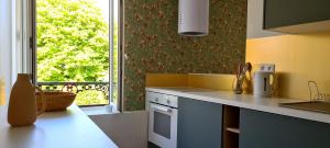 a kitchen with a counter and a window at L'App'Art d'Auvers in Auvers-sur-Oise